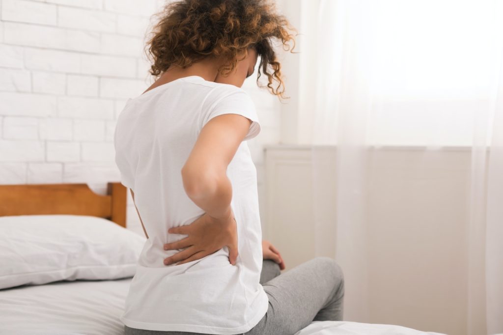 African-american woman having back pain after sleep