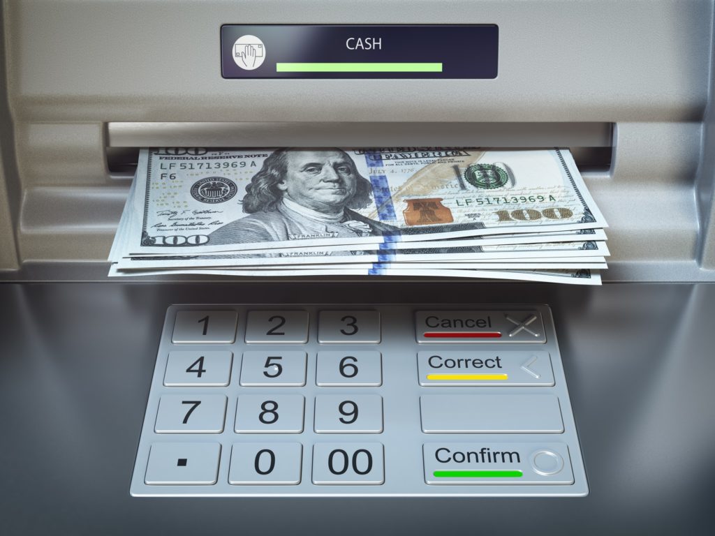 ATM machine and money. Withdrawing dollar banknotes.