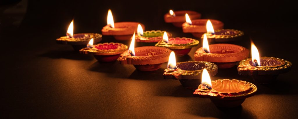 Diwali, Hindu festival of lights celebration. Diya oil lamps against dark background,