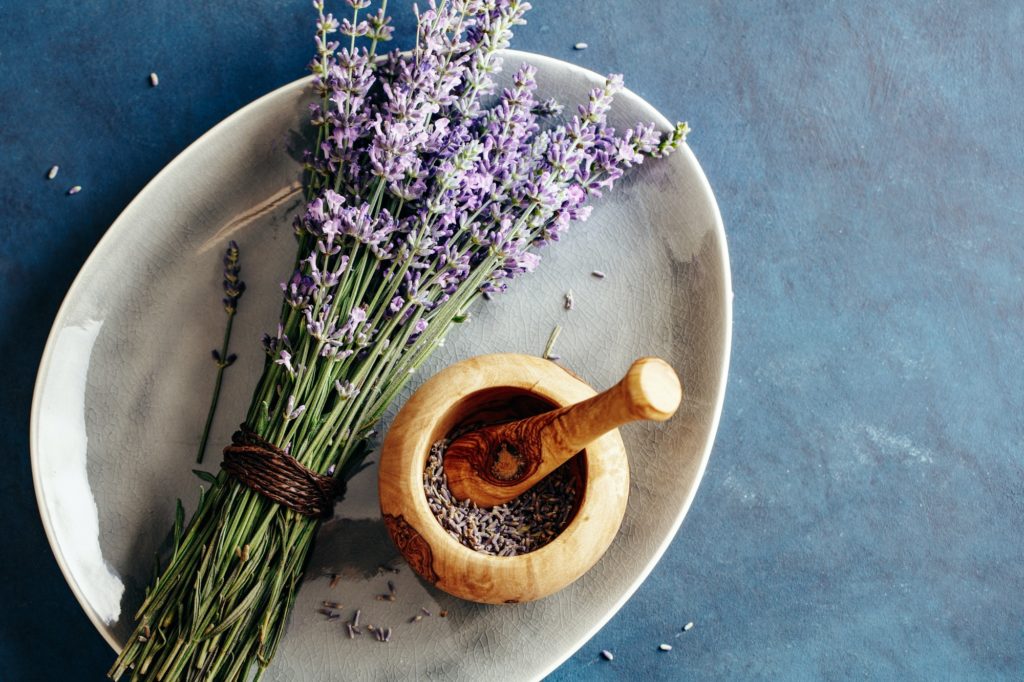 Fresh bundle of lavender and wooden mortar with lavender flowers