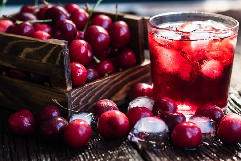 Fresh cherries in a wooden box, ice, cherry juice