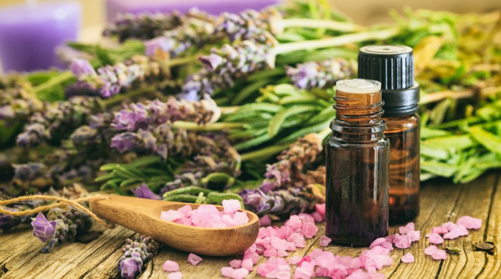 Fresh lavender, essential oil and bath salt on wooden background