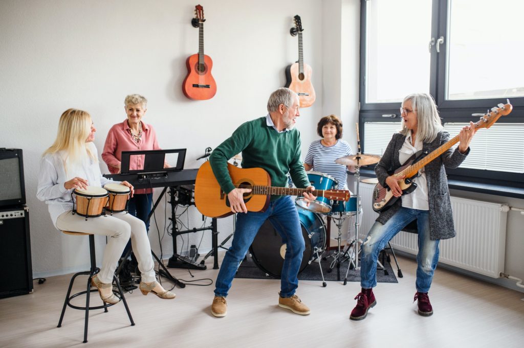 Group of senior people playing musical instruments indoors in band