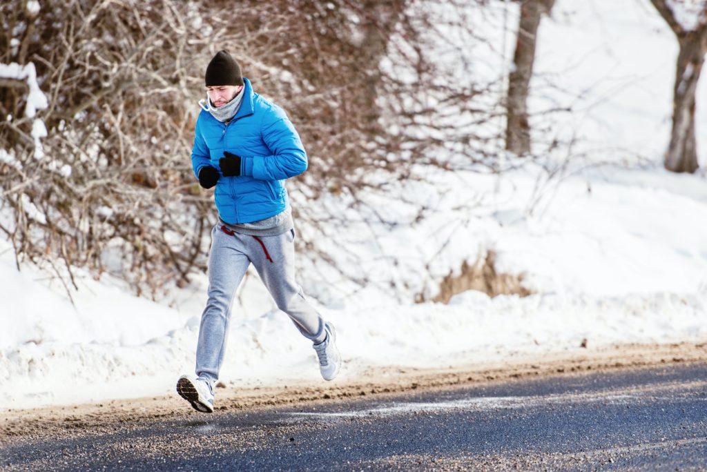 Male athlete working out on snow, running and fitness training