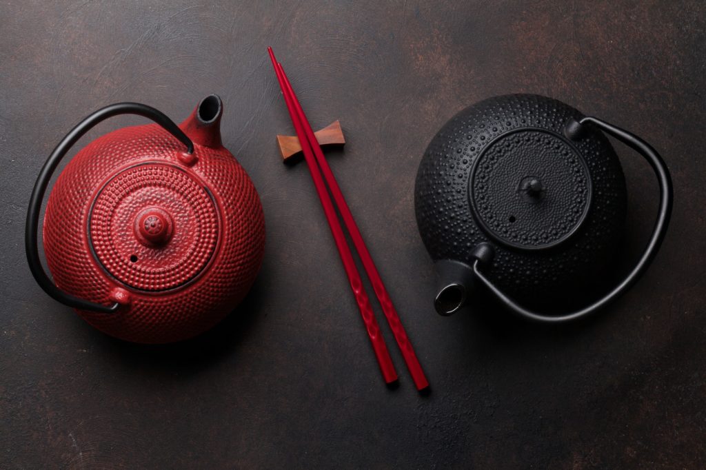 Red and black tea pots and sushi chopsticks