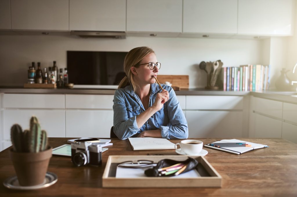 Young female entrepreneur deep in thought while working from home