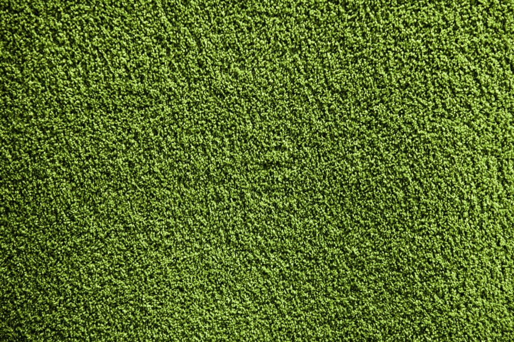 Artificial green carpet texture close-up background