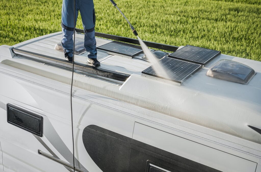 RV Industry Worker Cleaning Camper Van Roof and Motorhome Solar Panels