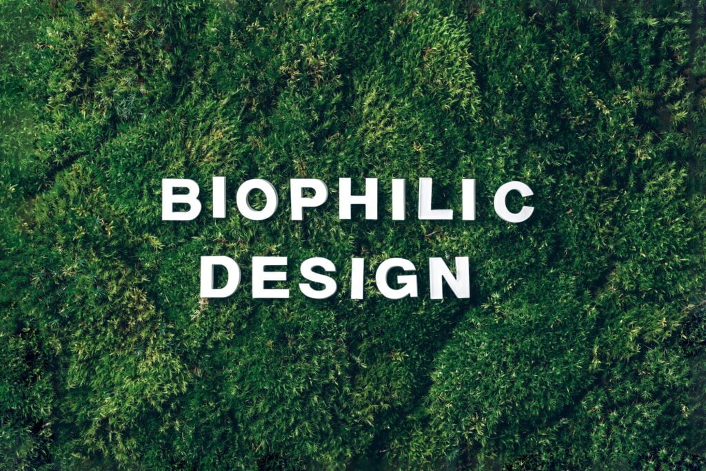 Biophilic design - white letters on green moss, grass background. Top view, copy space. Biophilia